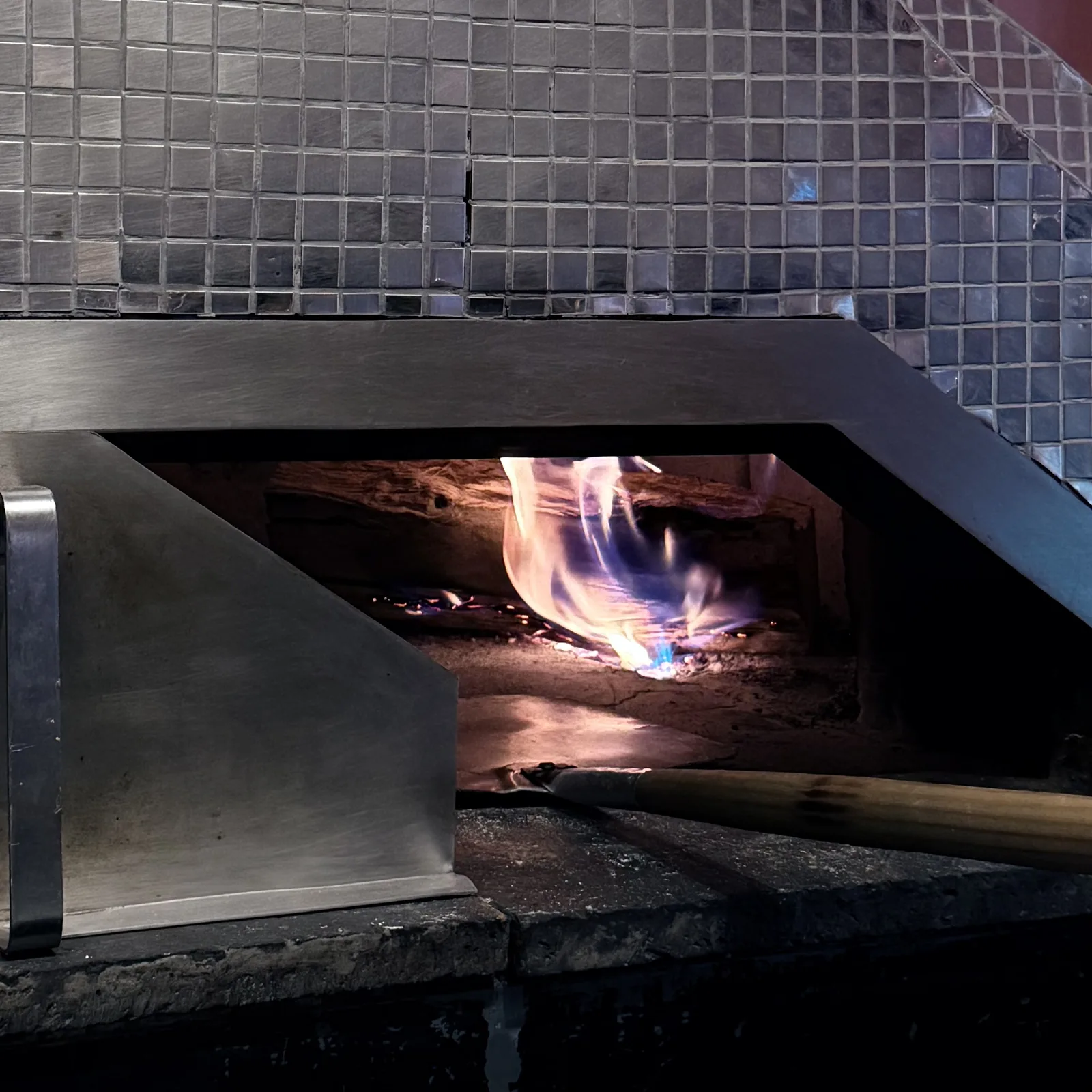 La boca del horno de leña con la lumbre encendida.