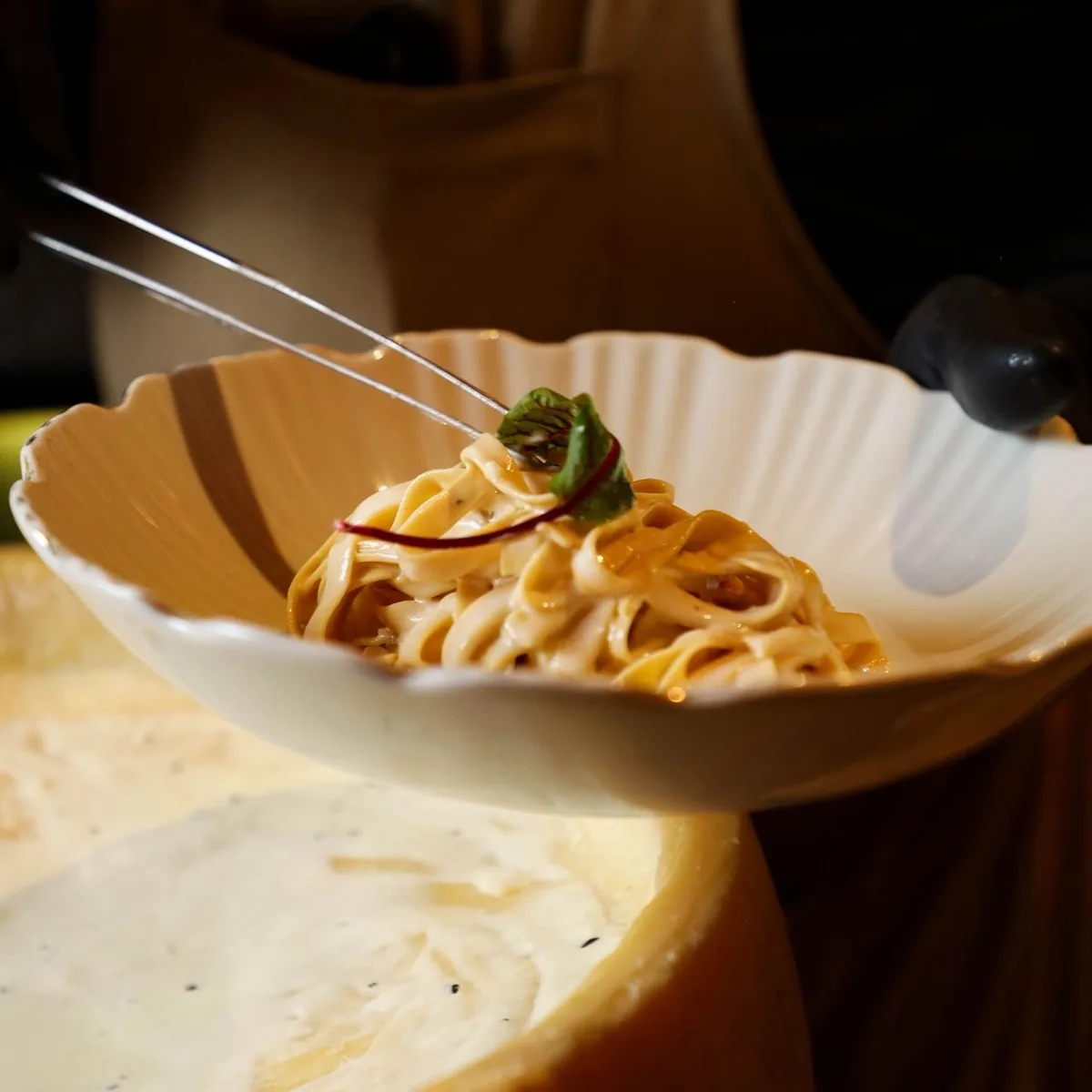Fettuccine terminado en rueda de parmesano.