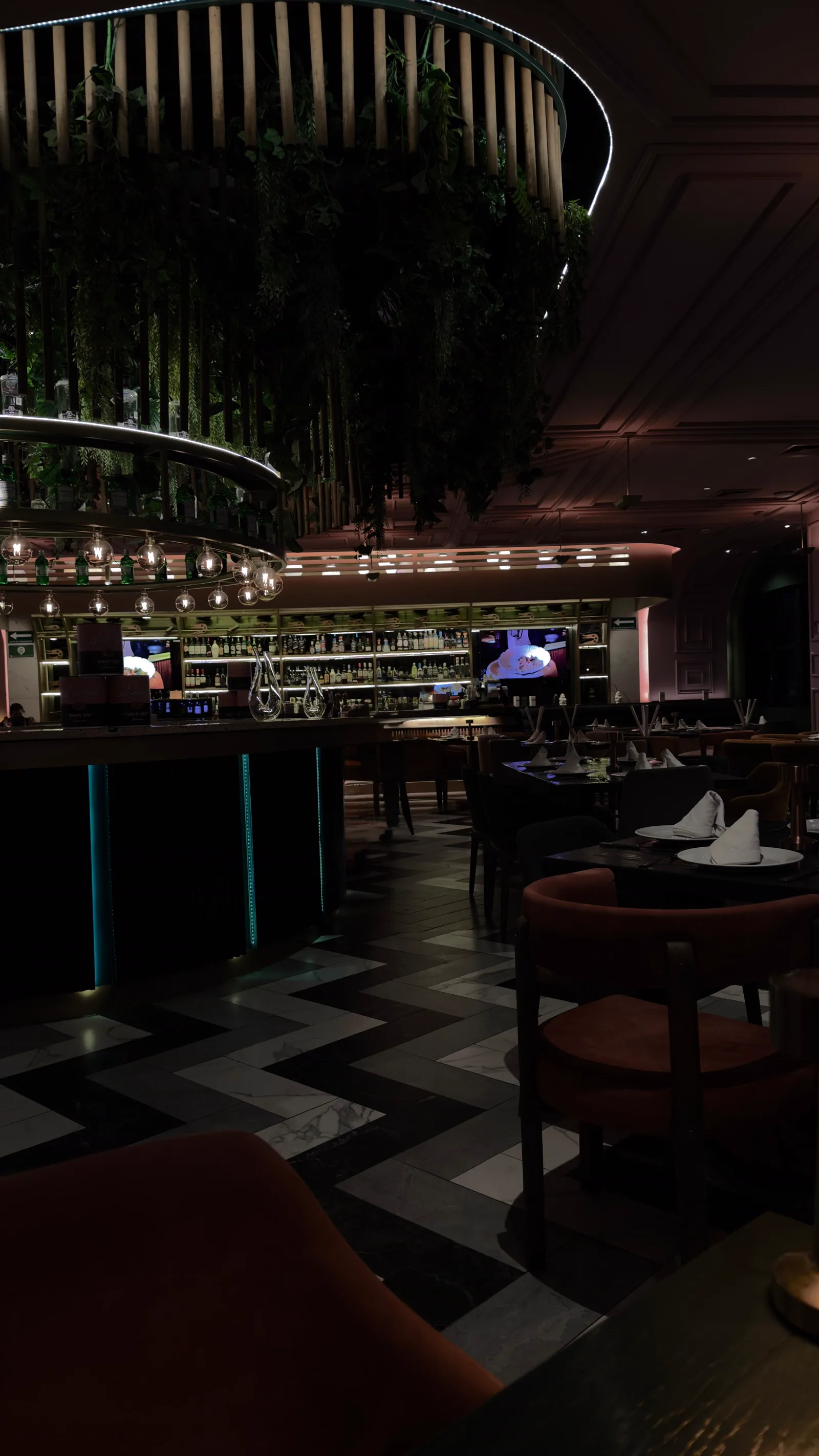 El salón de noche, con la barra del fondo encendida.